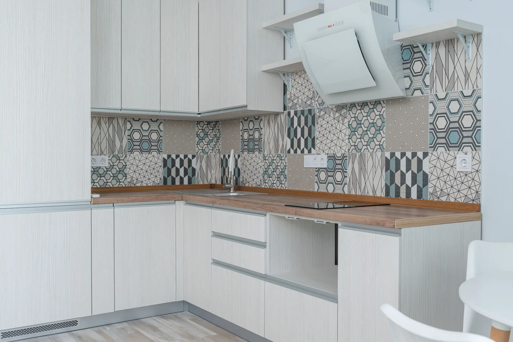 Hexagon-based geometric pattern backsplash in a compact corner kitchen