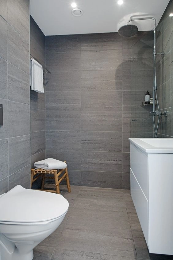 Large-format gray stone-look wall and floor tile in a modern walk-in shower bath